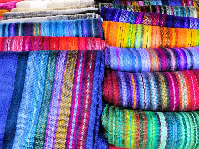 Colorful blankets on artisanal market in Otavalo, Ecuador — © DEZALB / Pixabay.